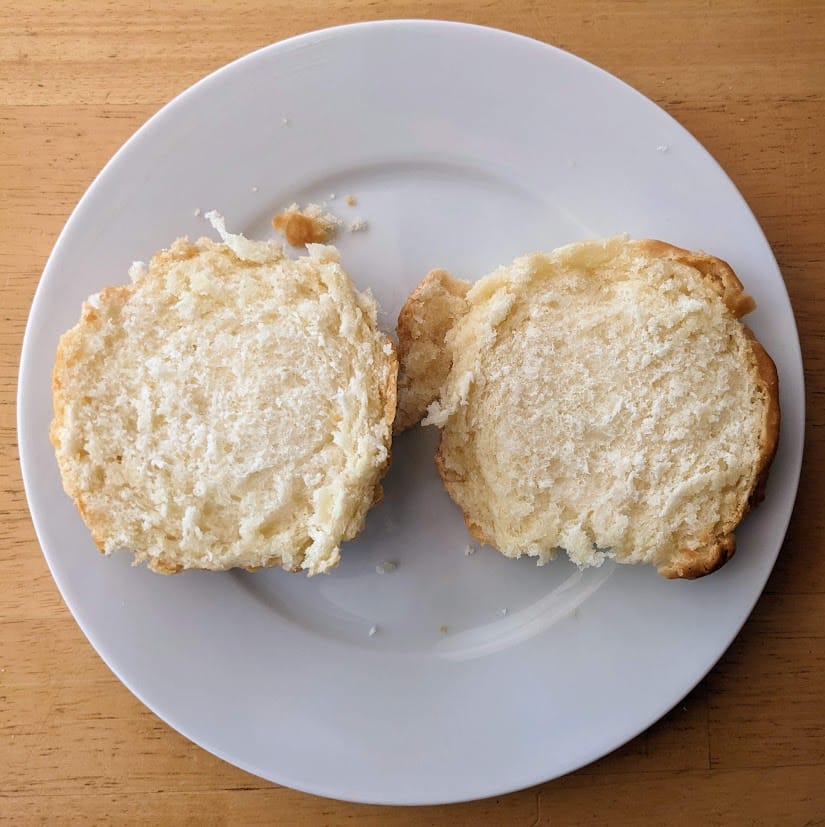 A white plate with two halves of a Costco Buttermilk Biscuit.