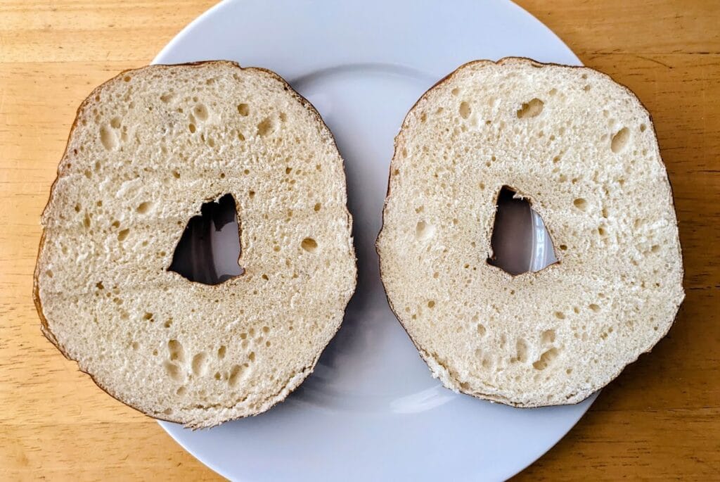 Two halves of a sliced Costco Pretzel Bagel on a plate.