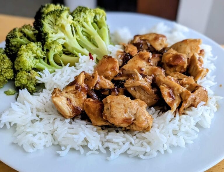 A pile of basmati rice topped with Kevin's Hawaiian-Style Chicken and a side of broccoli.