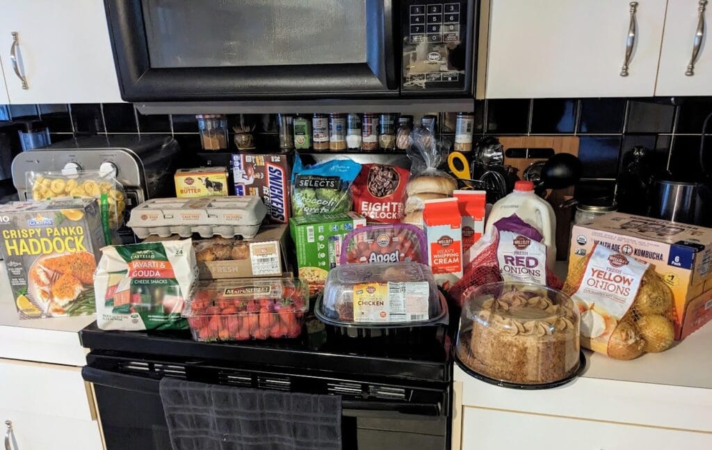Groceries from BJ's Wholesale Club stacked on top of a kitchen counter.