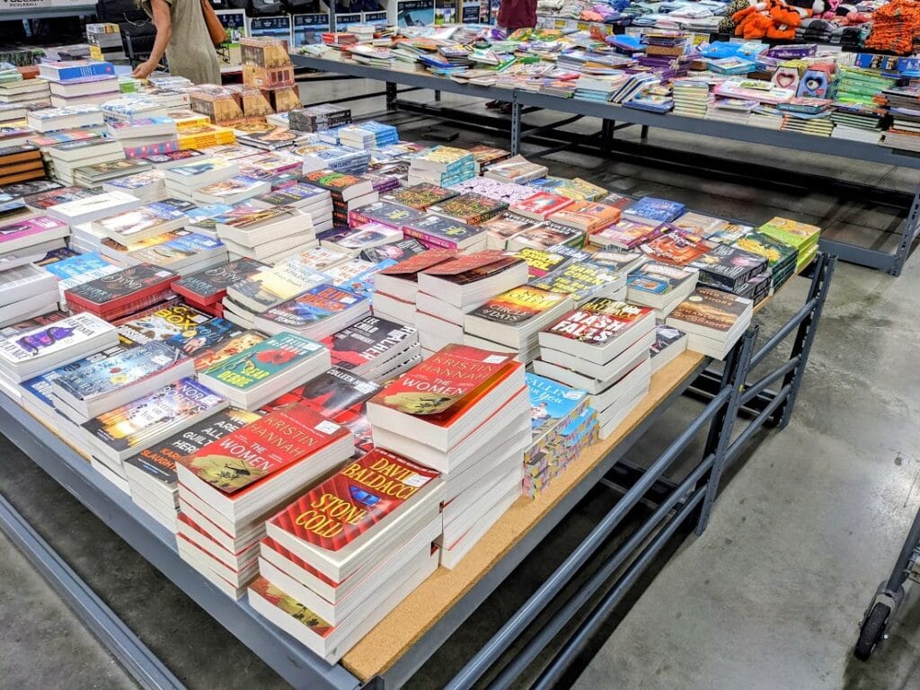 Two large tables covered with books inside a BJ's Wholesale Club.