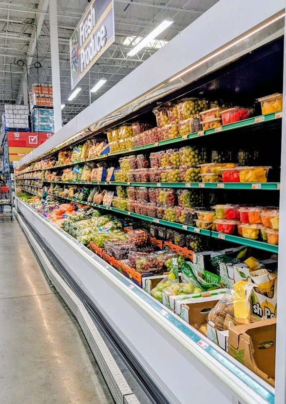 Long refrigerated shelves full of fruits and vegetables inside a BJ's Wholesale Club.