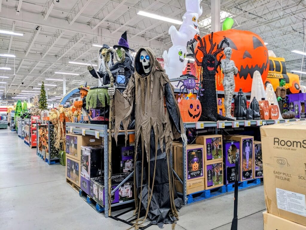 Holiday decor inside a BJ's Wholesale Club, featuring a cloaked skeleton and a giant pumpkin.