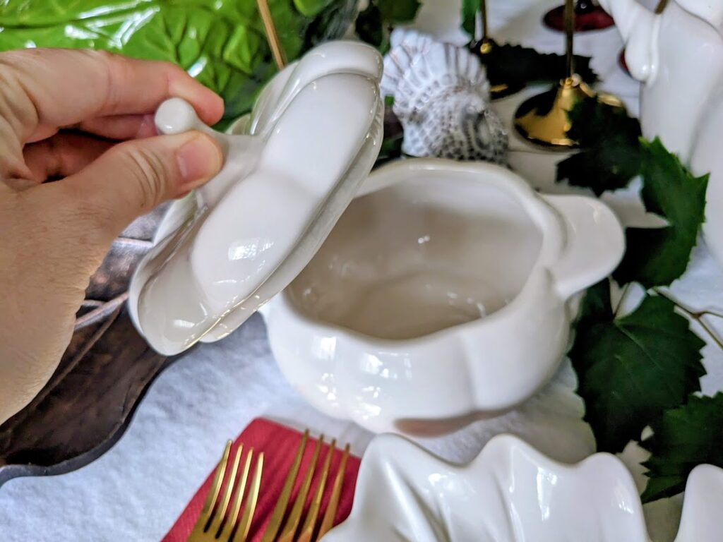 A hand holding the lid of a pumpkin-shaped coquette baker.